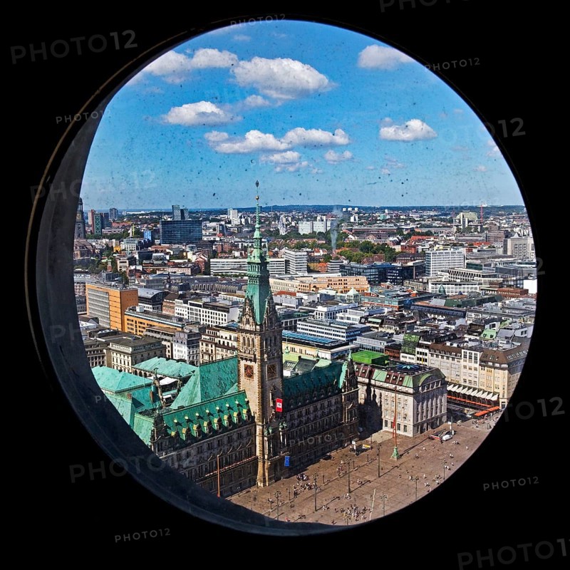 City view with the town hall through the porthole windows in the spire of the main church of St. Petri