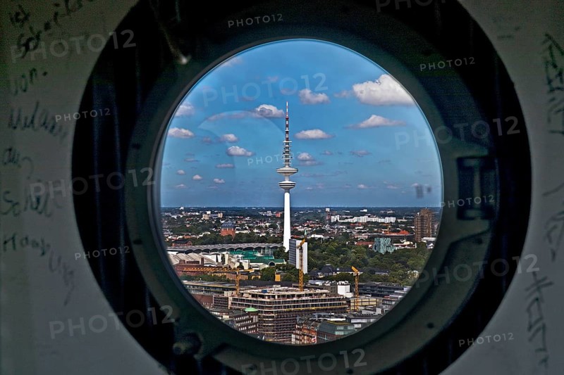 City view of the Heinrich Hertz Tower through the porthole windows in the spire of the main church of St. Petri