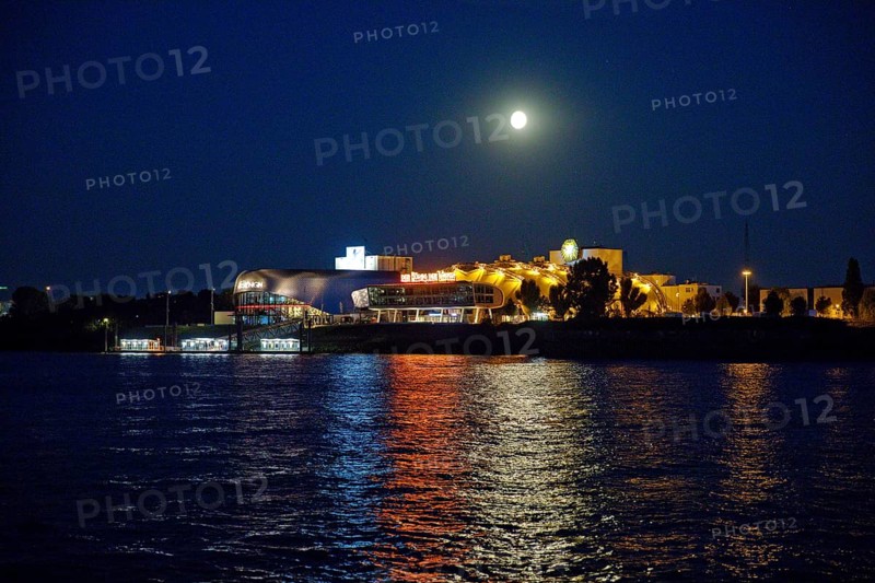 Atmospherically illuminated Stage Theater with the Elbe in the evening with full moon