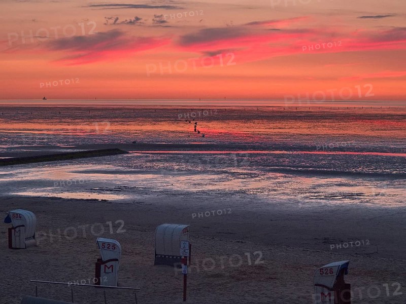 Beach chairs in the late evening on the beach of Cuxhaven with a view of the Elbe estuary