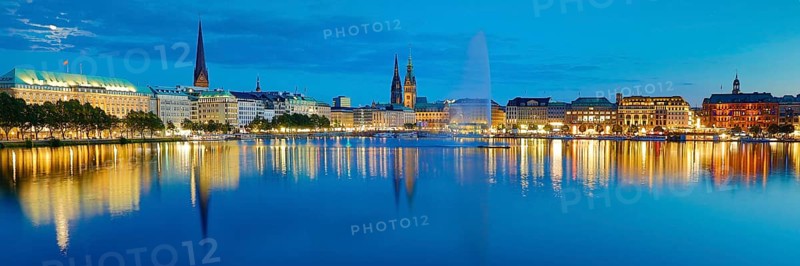 Inner Alster with Alsterfontaine and city skyline in the evening