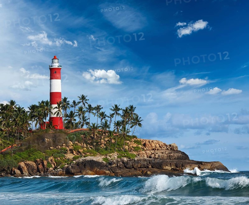 Old lighthouse and waves of sea. Kovalam