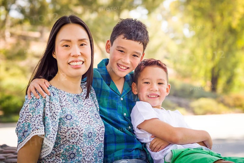 Outdoor portrait of biracial chinese and caucasian brothers and their mother