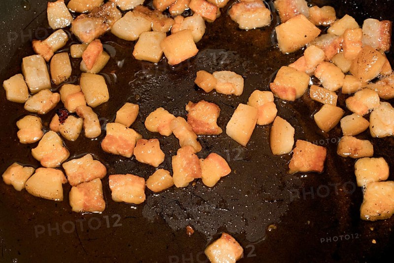 Pancetta cubes are fried in a pan