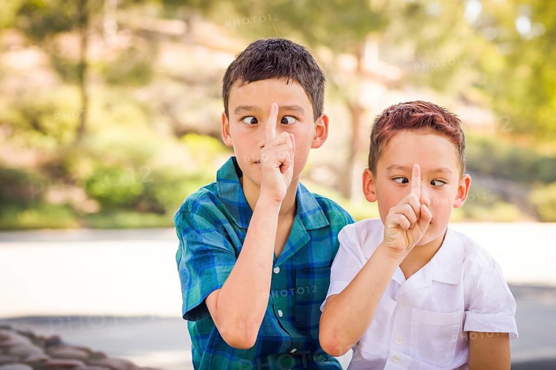Outdoor portrait of biracial chinese and caucasian brothers having fun