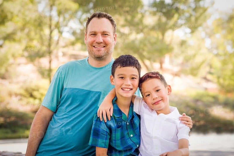 Outdoor portrait of biracial chinese and caucasian brothers and their father