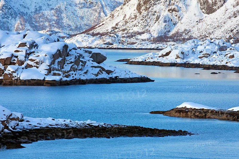 Mountains in the snow in winter by the fjord of Henningsvaer