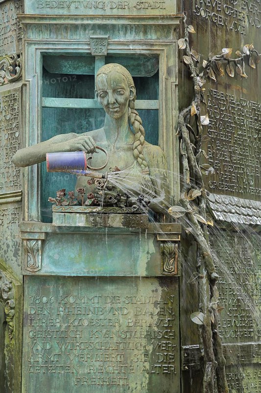 Minster fountain by Klaus Ringwald 1989 with detail figure of a woman watering flowers with watering can