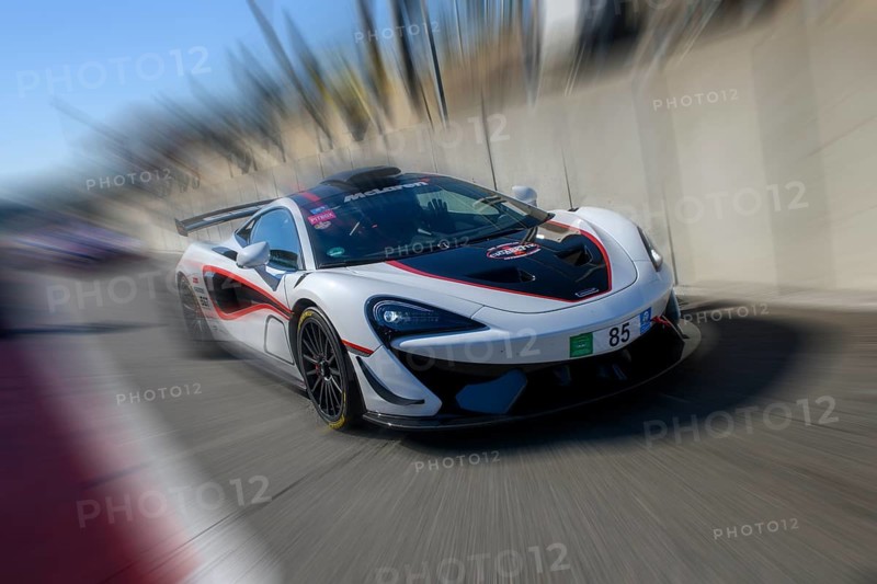Dynamic photo with zoom effect of sports car racing car McLaren 620R leaving pit lane