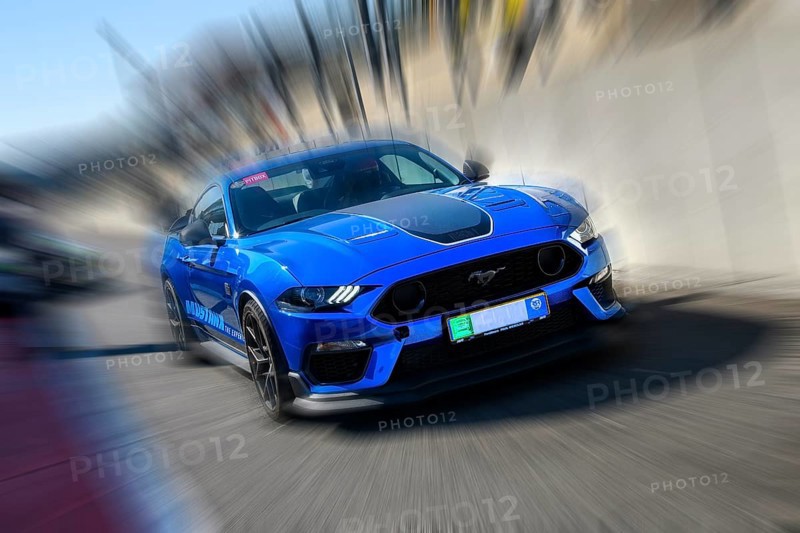 Dynamic photo with zoom effect of sports car race car Ford Mustang leaving pit lane