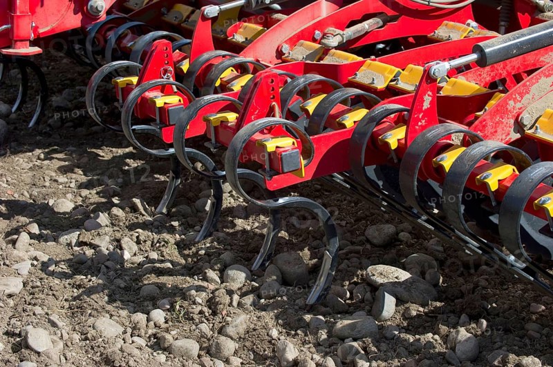 Close-up of Vaderstad Spirit 800S cultivator seed drill tines in a stony soil field