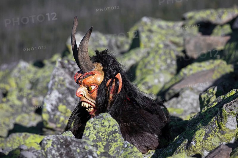 Creepy wooden devil figure on the summit of the Lusen in autumn