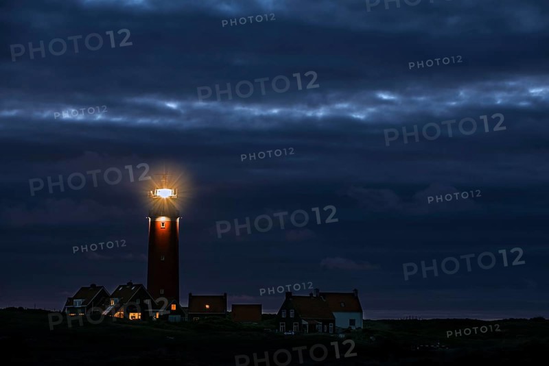 Eierland lighthouse with lantern light over the Wadden Sea at night on the Dutch island of Texel
