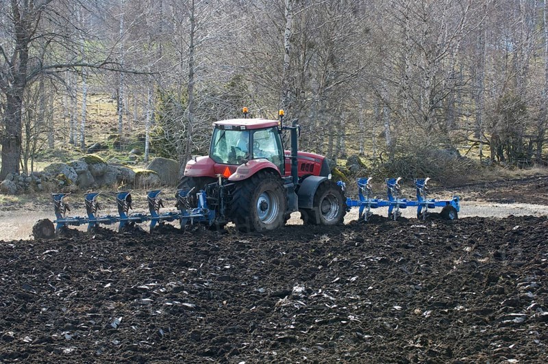 Tractor ploughing with front- and rear-mounted plough