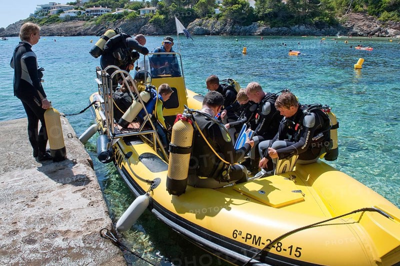 Diver in dinghy at pier
