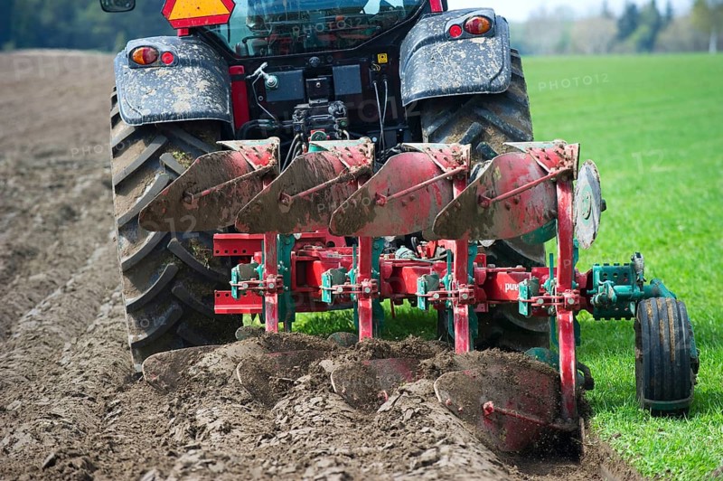 Valtra tractor ploughs field with four-furrow reversible plough