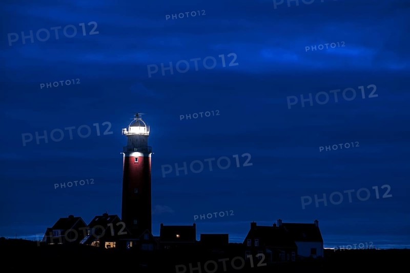 Eierland lighthouse with lantern light over the Wadden Sea at night on the Dutch island of Texel