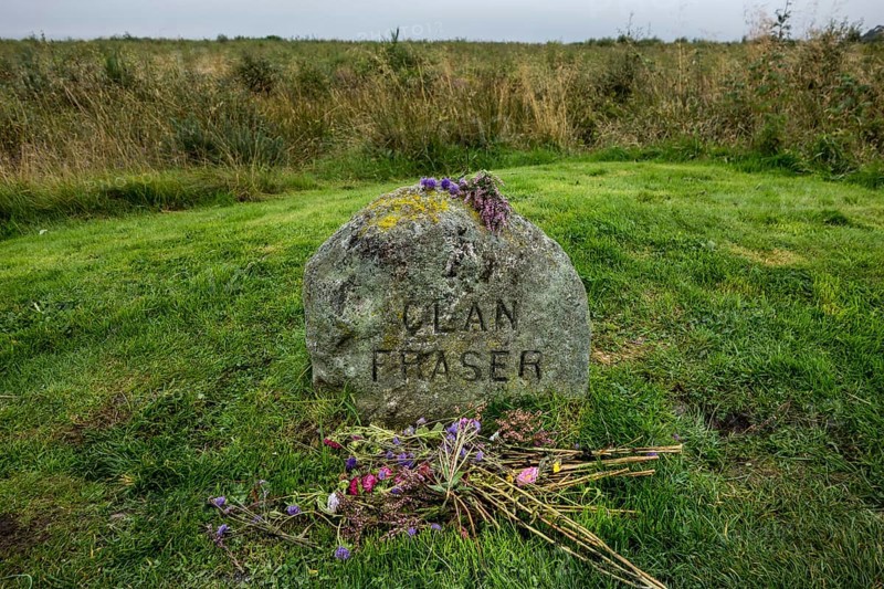 Flowers at the gravestone marking the mass grave of the fallen Jacobite soldiers of Clan Fraser on the battlefield of Culloden near Inverness