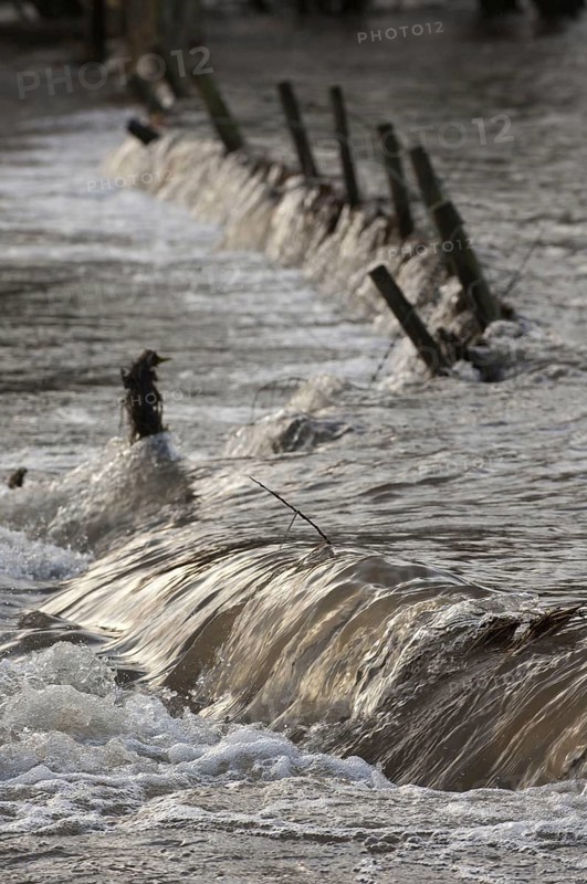Flooded farmland with damaged fence