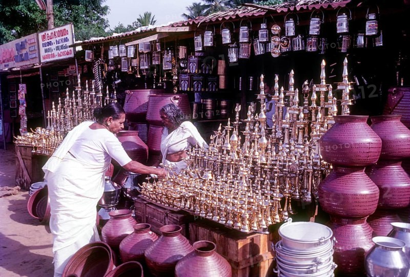 An old women purchasing brass oil lamps in a shop in Ernakulam