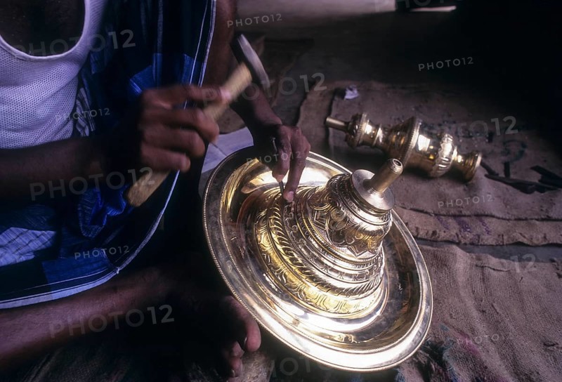 An artisan working on brass lamp at Nachiyar Koil near Thanjavur