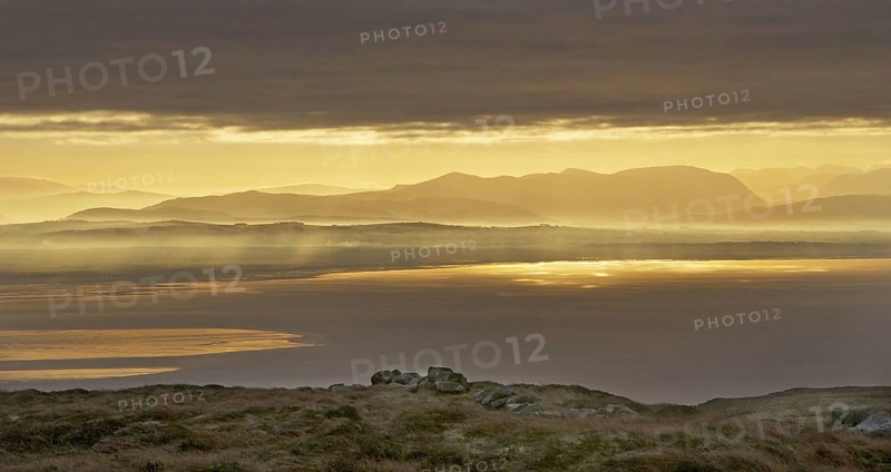 View across bay towards distant hills at sunrise