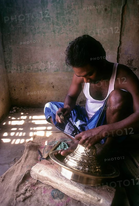 An artisan working on brass lamp at Nachiyar Koil near Thanjavur