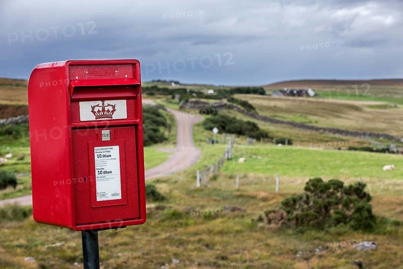 Traditional red Royal Mail letterbox in the bleak landscape at Coigach