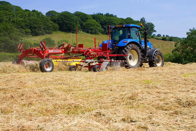 Contractor with New Holland T7030 tractor and SIP hay tedder
