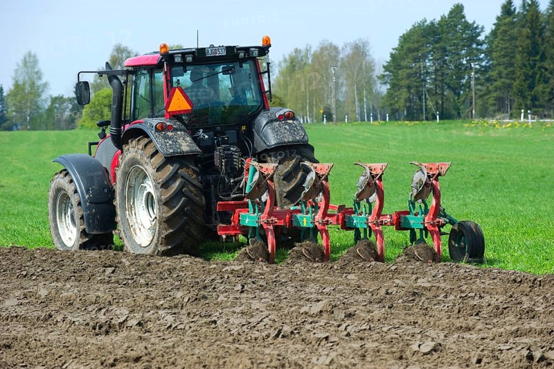 Valtra tractor ploughs field with four-furrow reversible plough