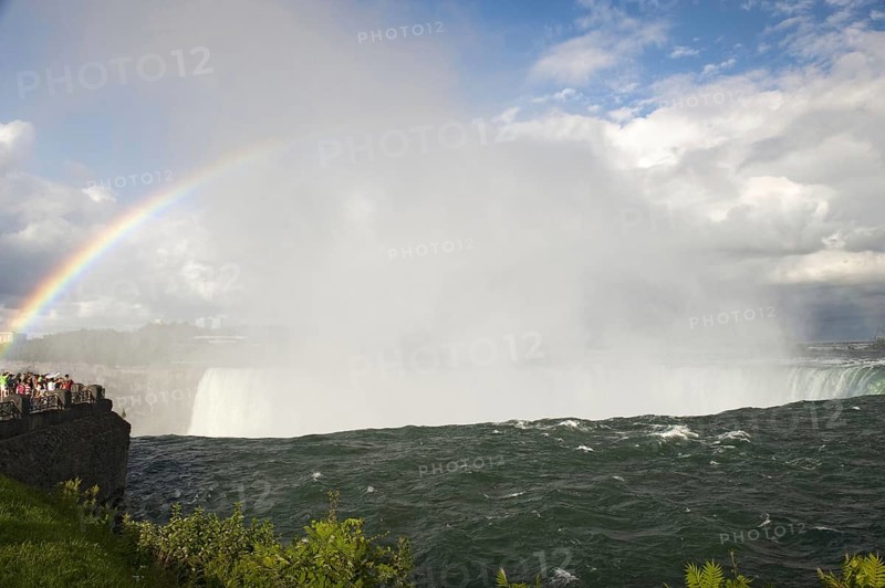 Rainbow forming in spray over waterfall