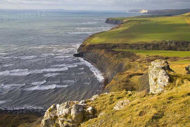 View of coastline with farmland and rough sea from high cliff