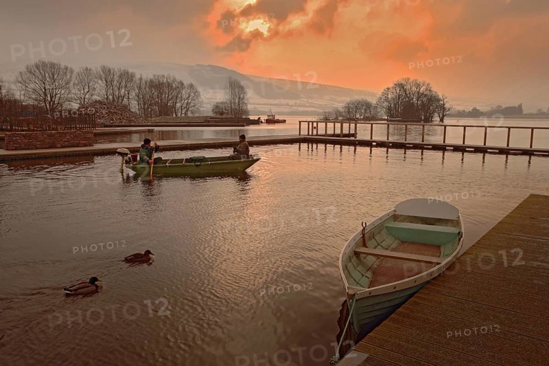 Anglers in a boat at dawn on the lake