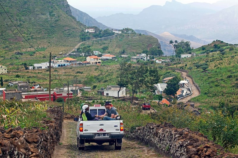 Tourists and locals transported in the back of the pickup truck in the rural landscape on Sao Nicolau Island