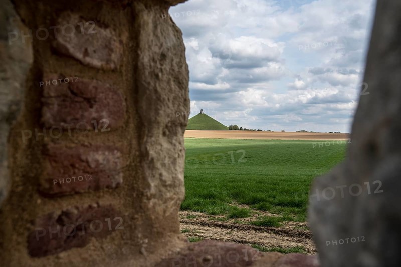 View over the Waterloo battlefield and Lion's Hill through a loophole in the garden wall of the Chateau d'Hougoumont