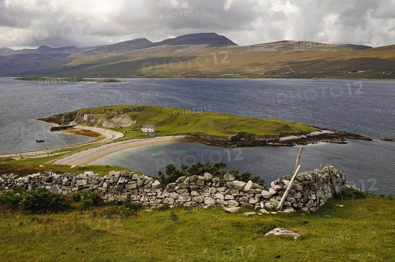 View of land in sea loch connected to mainland by tombolo promontory