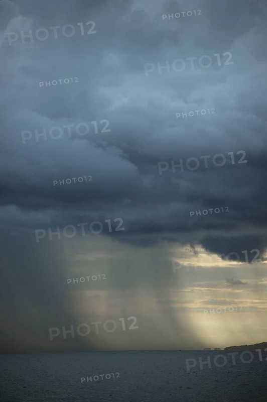 Rainstorm approaching over sea at dusk