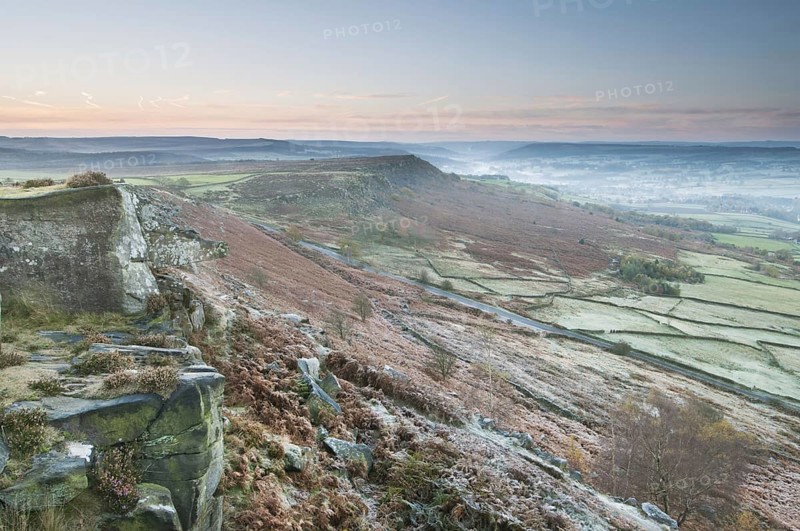 View of cliffs and moorland across valley in frost at sunrise