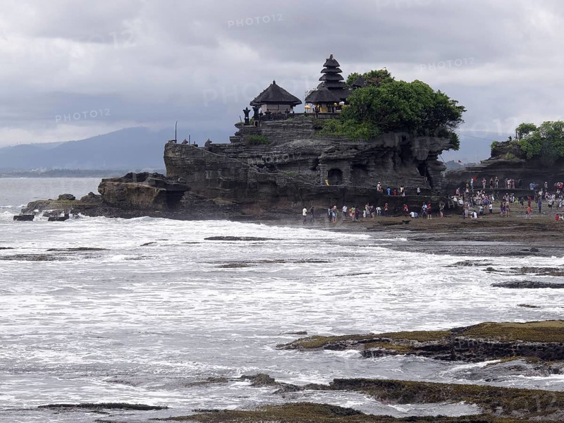 View from tourists in the temple on a rock formation on the coast