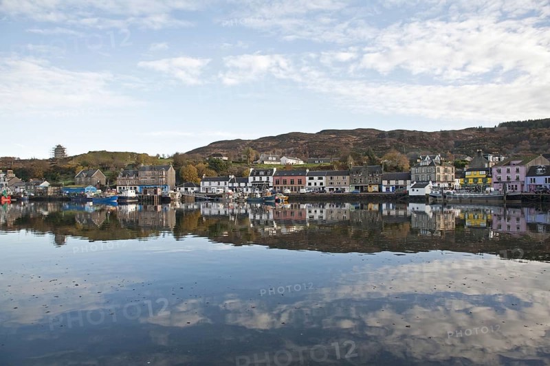 View of boats moored at town harbour in sea loch