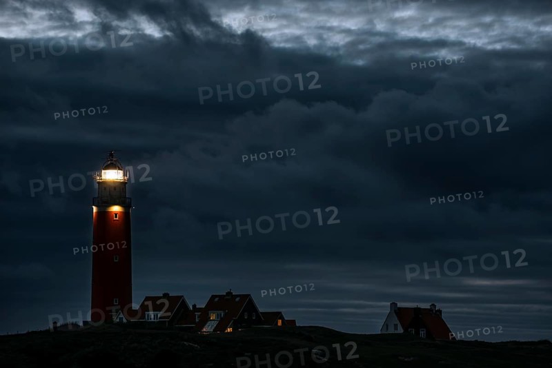 Eierland lighthouse with lantern light over the Wadden Sea at night on the Dutch island of Texel