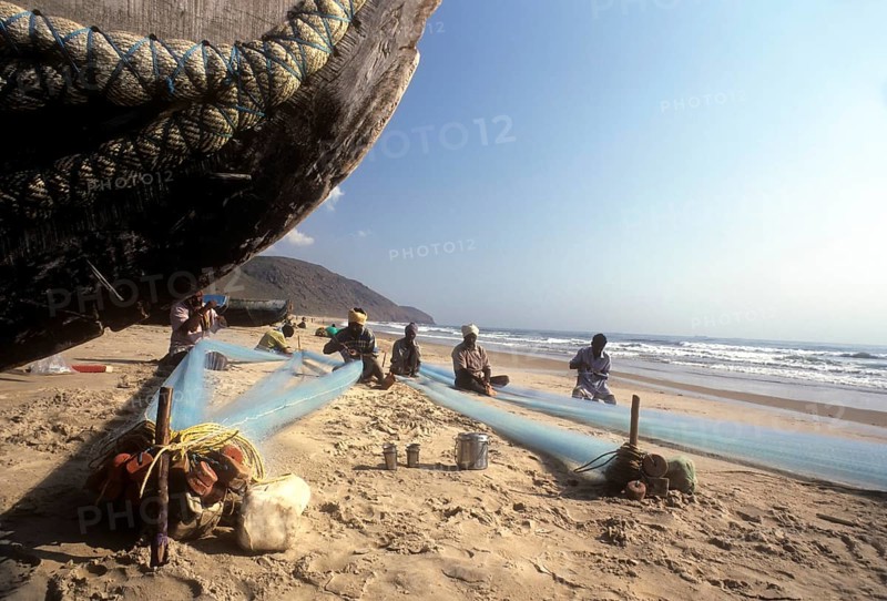 Fishermen repairing their fishing nets in Gangavaram