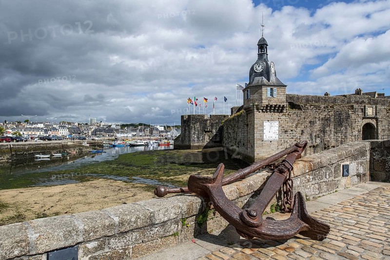 Old anchor and bell tower at the entrance gate to the medieval Ville Close in Concarneau