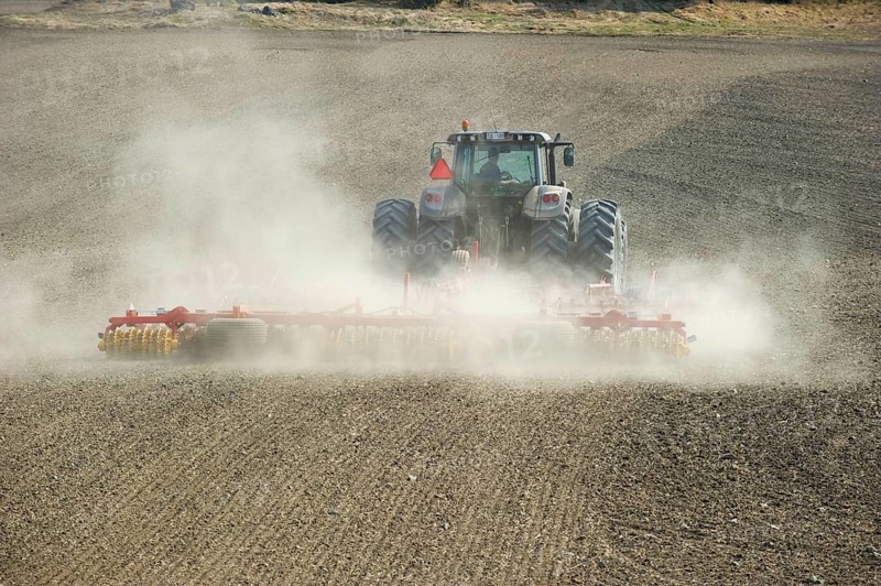 Valtra tractor with Vaderstad NZA-800 and Vaderstad RS-820 harrows and rollers working dusty farmland