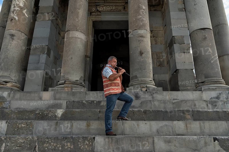 Armenian playing the traditional duduk in front of the Hellenistic Temple of the Sun in Garni