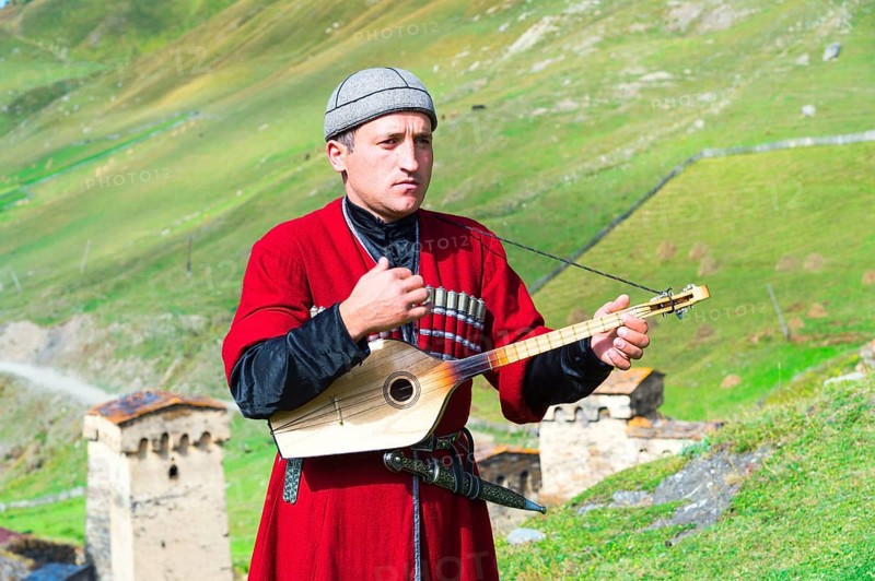 Georgian musician of a folklore group playing panduri
