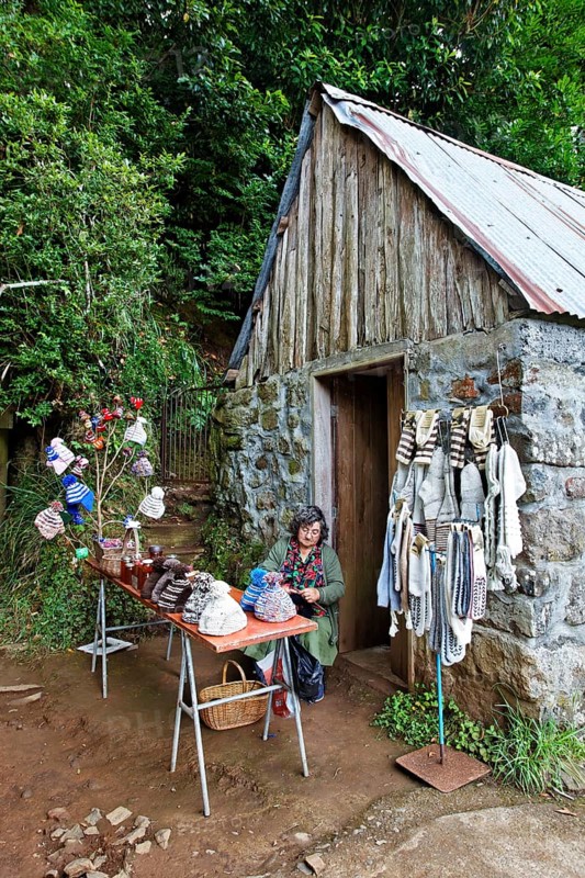 Woman sitting in front of stone house