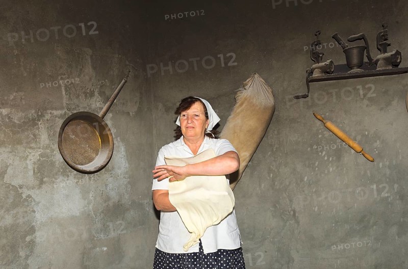 Armenian woman preparing Armenian lavash bread in the traditional tandoor oven