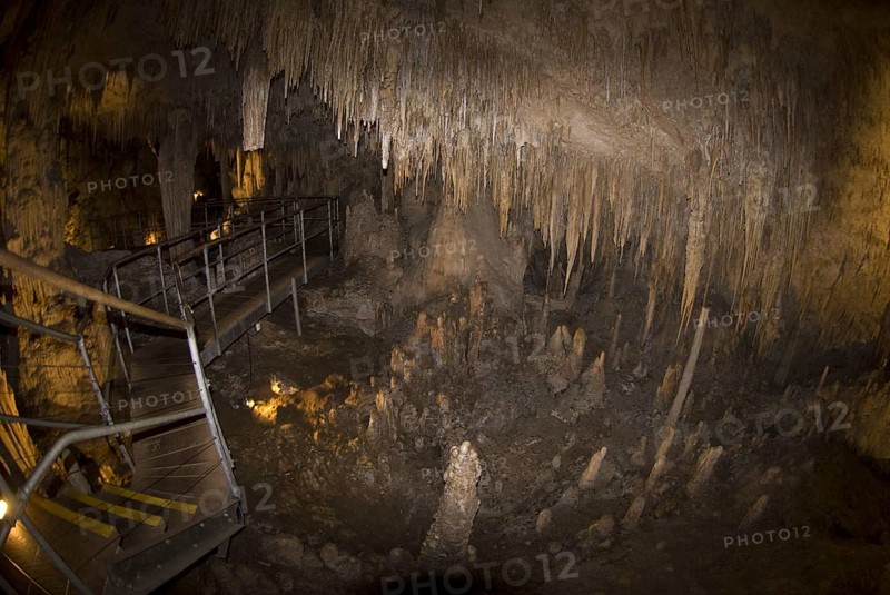 Steps and promenade through a cave with stalactites and stalagmites