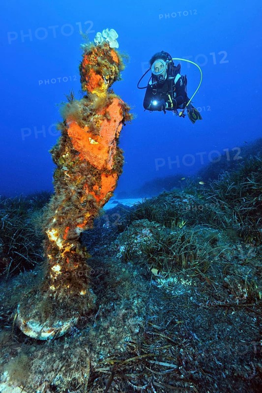 Diver and statue of the Madonna under water